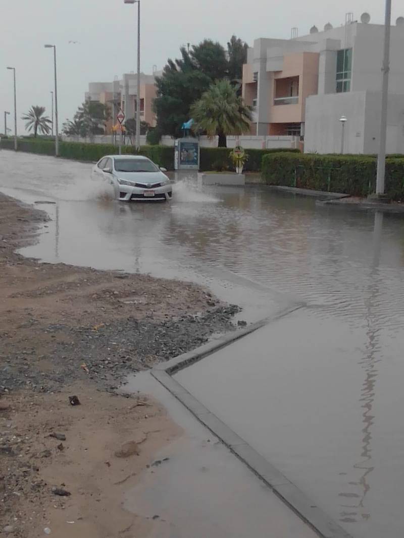 A car drives through a waterlogged road near Al Bateen airport. Scott Walker
