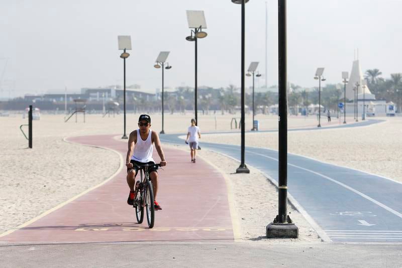 DUBAI, UAE. September 11, 2014 - Brian Jurado Baloro bikes along the path at the Jumeirah Open Beach in Dubai, September 11, 2014. (Photos by: Sarah Dea/The National, Story by:  Nadeem Hanif, News)