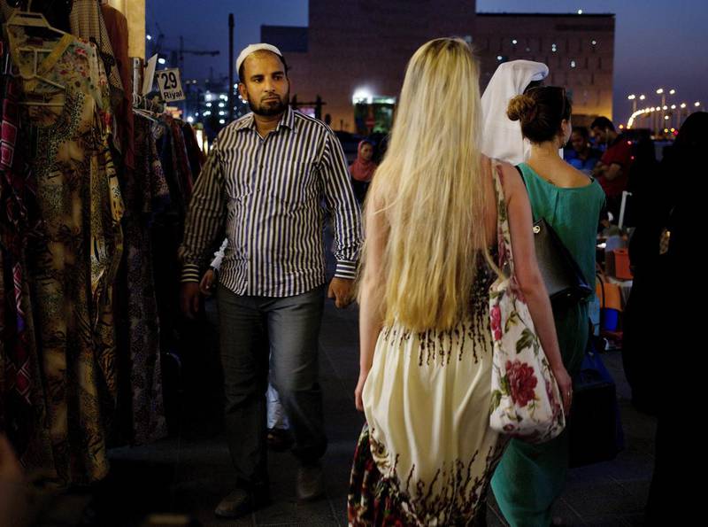 A foreign woman walking past at Souq Waqif in Doha, Qatar. A campaign called 'Reflect Your Respect' that promotes modest clothing in the country has been launched to encourage foreign women to dress more conservatively. Razan Alzayani/AP Photo