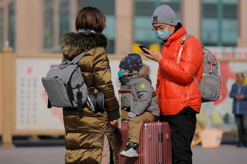 Passengers wear masks at the Beijing railway station. EPA