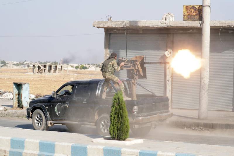 A Turkey-backed Syrian rebel fighter fires a weapon in the town of Tal Abyad, Syria October 13, 2019. Reuters
