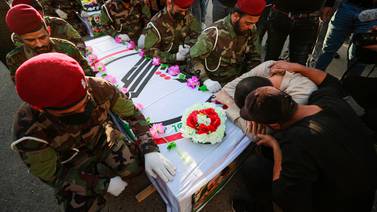 Iraqis cry next to the coffin of a fighter killed in a US strike during a funeral in Baghdad in November. AFP
