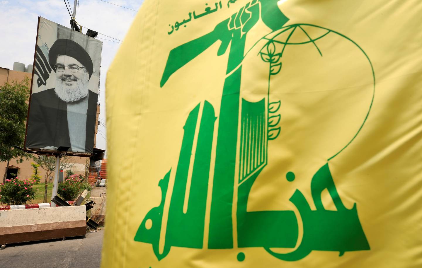 A Hezbollah flag and a poster depicting Lebanon's Hezbollah leader Sayyed Hassan Nasrallah. Reuters
