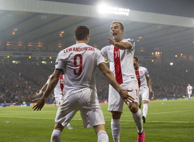 Poland's Robert Lewandowski celebrates with teammates after scoring one of his two goals in a 2-2 draw with Scotland on Thursday night in Glasgow. Robert Perry / EPA / October 8, 2015  