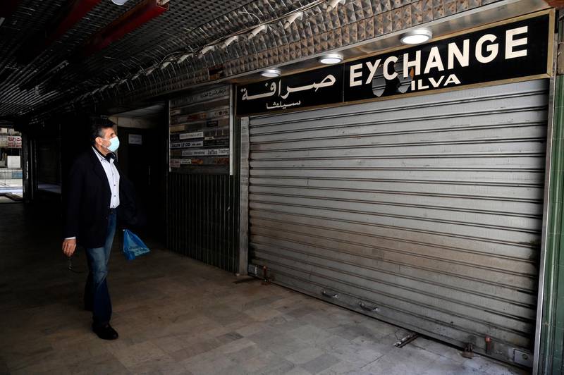 epa09079730 A man walks in front of a closed currency exchange shop at Hamra street in Beirut, Lebanon, 17 March 2021. The Lebanese pounds was exchanging at around 14,500 to the US dollar after the Lebanese pound has lost more than 85 percent of its value against the dollar on the black market in the worst economic crisis in Lebanon.  EPA/WAEL HAMZEH