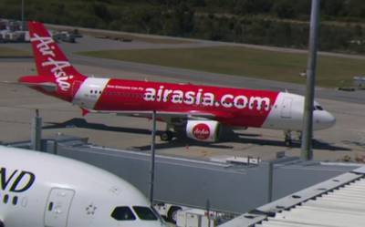 This Sunday, Oct. 15, 2017 image made from video shows an AirAsia plane at an airport in Perth, Australia. Passengers on the Indonesia AirAsia flight from Australia to the holiday island of Bali described a panicked flight crew announcing an emergency and oxygen masks dropping from the ceiling after their airliner lost cabin air pressure and rapidly descended. (Channel 9 via AP)
