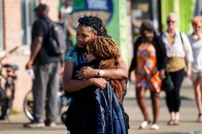 People embrace near the scene of the fatal mass shooting in Buffalo. AP