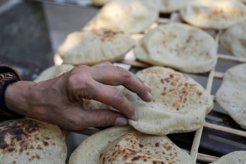 A woman checks bread she bought a bakery in Cairo. Reuters