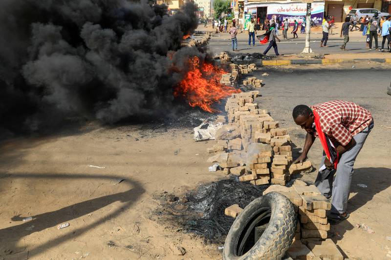 Sudanese protesters use bricks and burning tyres to block 60th Street in Khartoum.
