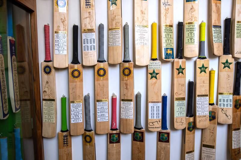 Cricket bats featuring key statistics of international cricket stars including Australia's Shane Warne.