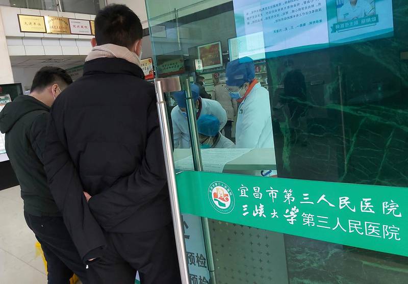 Hospital staff wear face masks as they work at a check-in desk at a hospital that reported a coronavirus death in Yichang in central China's Hubei Province. Chinatopix via AP