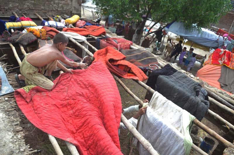 People who escaped the floods dry their belongings at a camp in the Sanghar district of Sindh province in Pakistan. EPA