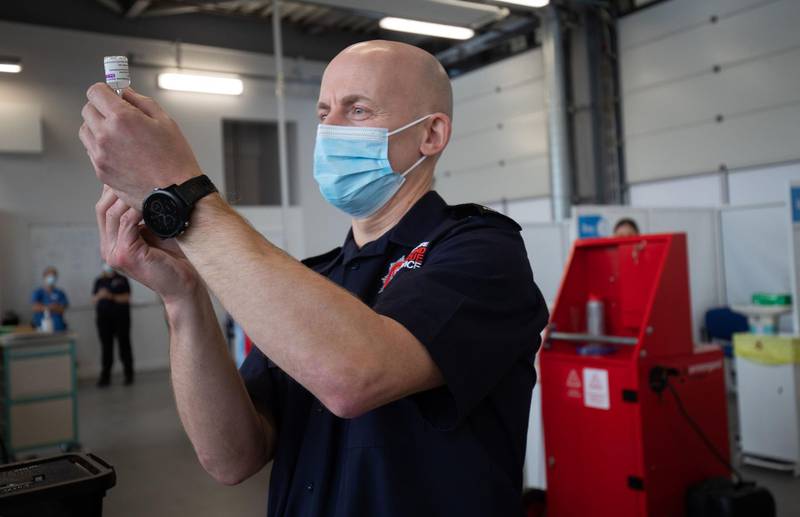 A member of the Hampshire Fire and Rescue Service prepares a dose of a AstraZeneca/Oxford Covid-19 vaccine at Basingstoke Fire Station. AFP