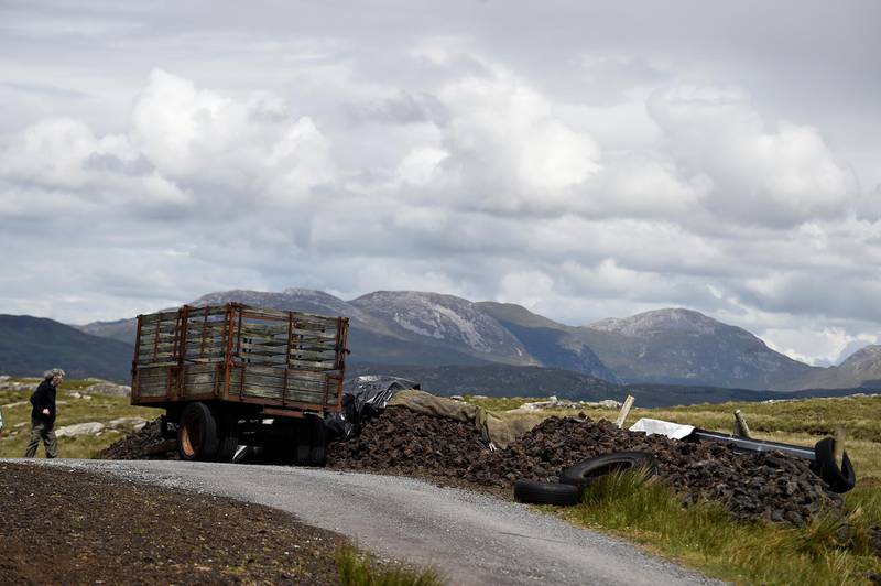 A general view of stacked turf beside a trailer in a peat bog in the Connemara region of Derrygimlagh, Ireland, June 15, 2019. Picture taken June 15, 2019. REUTERS/Clodagh Kilcoyne