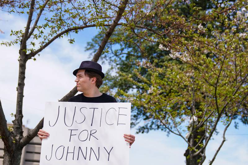 Depp fan David Laman holds a poster outside the Fairfax County Circuit Courthouse as jury selection progressed.  Reuters