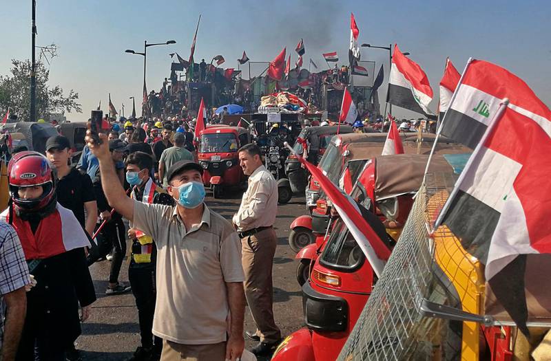 Anti-government protesters take control of the first barriers set by Iraqi security forces to close the Joumhouriya bridge leading to the Green Zone during ongoing protests in Baghdad, Iraq, Saturday, Nov. 2, 2019. (AP Photo/Khalid Mohammed)