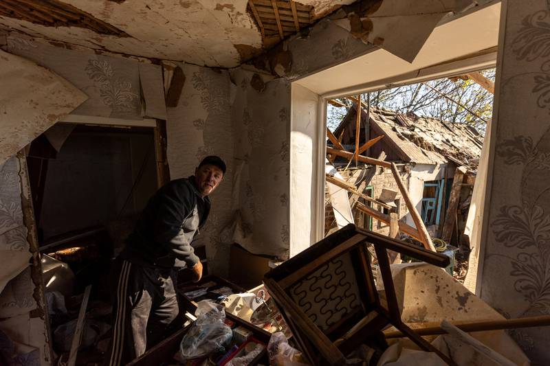 A man searches for useful items inside his house after a missile strike in a residential area, in Bakhmut. Reuters