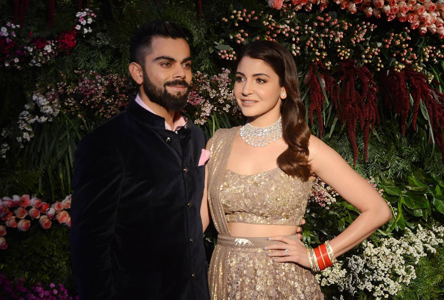 Indian cricketer Virat Kohli (L) and Bollywood actress Anushka Sharma pose for a photograph during their wedding reception in Mumbai on late December 26, 2017. (Photo by STR / AFP)