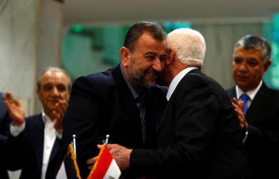 Head of Hamas delegation Saleh Arouri hugs Fatah leader Azzam Ahmad as they sign a reconciliation deal in Cairo, Egypt, October 12, 2017. REUTERS/Amr Abdallah Dalsh