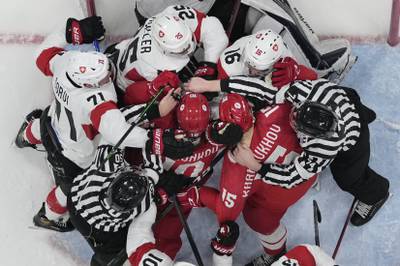 Russian Olympic Committee and Switzerland players fight as officials try to separate them during a preliminary round men's hockey game at the 2022 Winter Olympics. AP