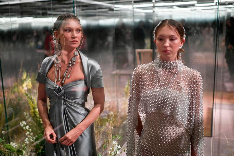 Kate Moss and her daughter, Lila Grace Moss, poses in their glass box on the Fendi runway. AFP