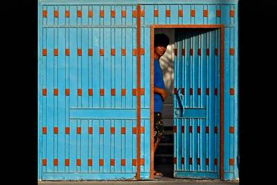 A man looks out from his villa's gate door in Satwa, Dubai City. Jeff Topping / The National