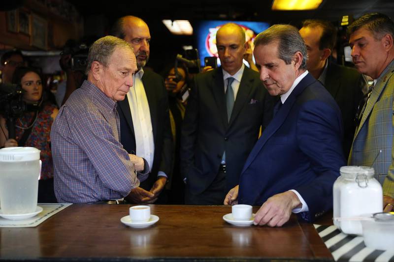 Democratic presidential candidate, former New York City mayor Mike Bloomberg; and Manny Diaz, former Miami Mayor, prepare to enjoy their Cuban coffee at El Pub Restaurant in the Little Havana neighborhood in Miami, Florida. AFP
