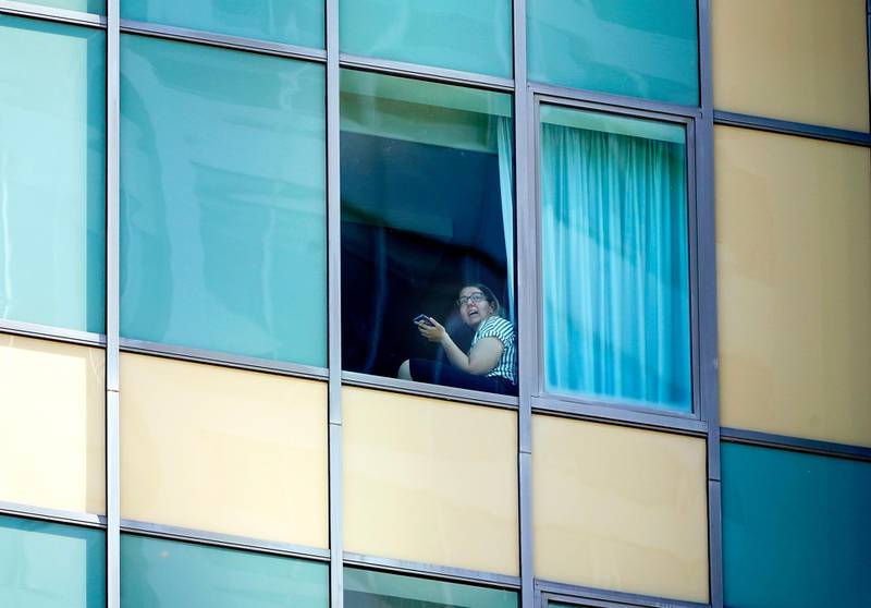 A quarantined traveller looks from a window at the Voco Hotel in Surfers Paradise, Queensland, Australia.  EPA