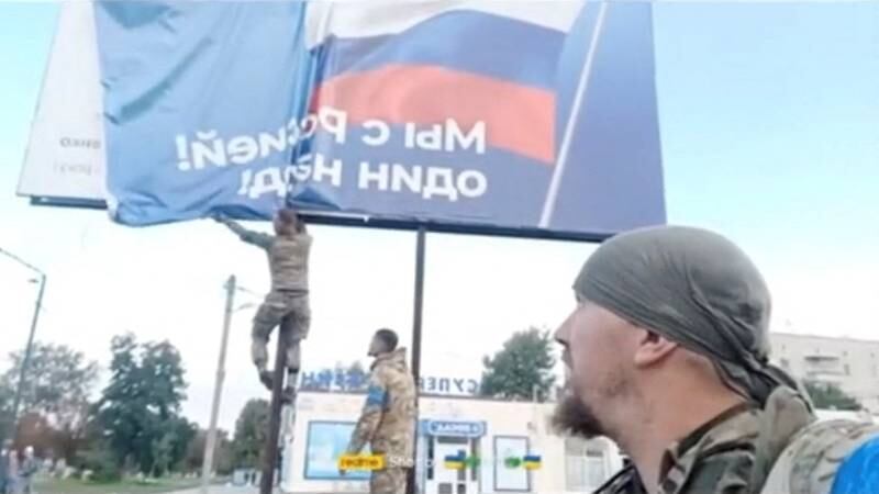 A Russian poster is pulled from a billboard to reveal a poem by Ukrainian Taras Shevchenko in Balakliia, Kharkiv. Reuters