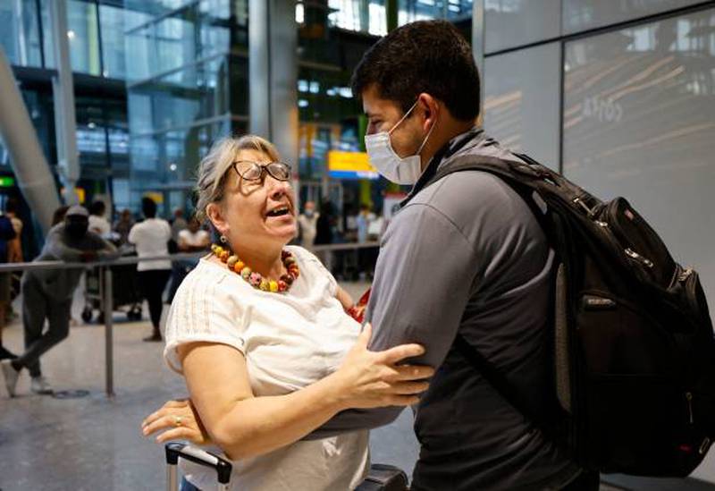 A mother embraces her son as he arrives from the US at Heathrow. People fully vaccinated in the US and EU, except France, can now travel to England without having to quarantine on arrival.