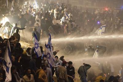 Israeli police use water cannon to disperse demonstrators blocking a road in Tel Aviv. AP
