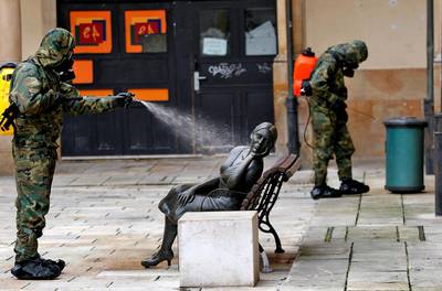 A soldier desinfects the sculpture 'La Bella Lola' in Oviedo, northern Spain. EPA
