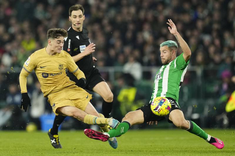 Barcelona's Gavi, left, fights for the ball with Betis' Aitor Ruibal. AP