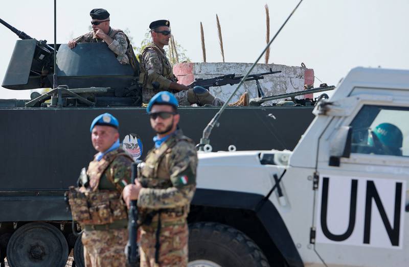UN peacekeepers stand guard as Lebanese troops sit on an armored vehicle in Naqoura, near the Israeli border. Reuters