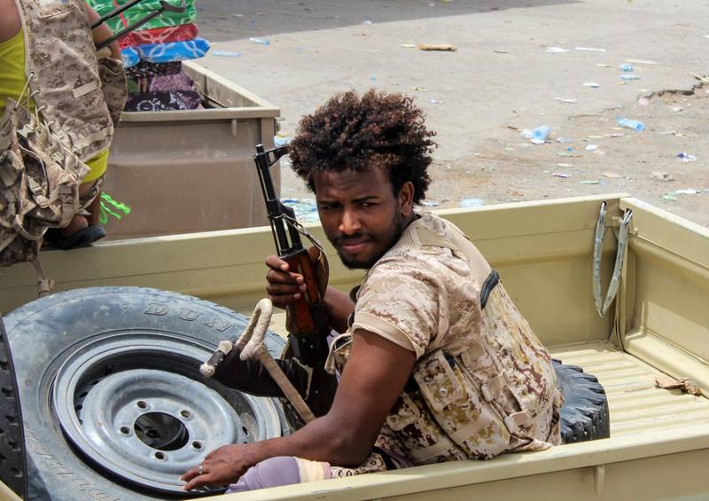 A Yemeni fighter from the Amalqa ("Giants") Brigades, loyal to the Saudi-backed government, rides in the back of a pickup truck during the offensive to seize the Red Sea port city of Hodeidah from Iran-backed Houthi rebels, on its southern outskirts of the near the airport on June 21, 2018. Saleh Al-Obeidi / AFP