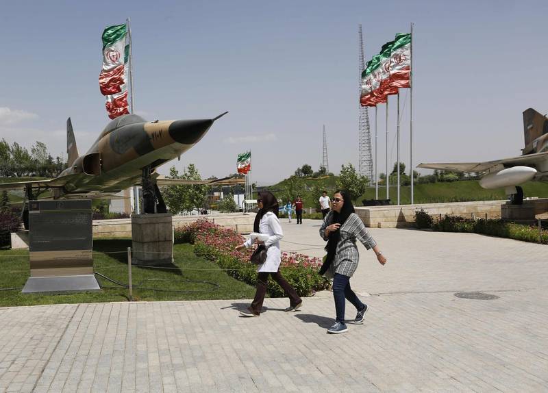 Iranians walk by a fighter jet at the Holy Defence Museum in the capital Tehran on July 17, 2018. The museum displays items from the 1980-88 Iran-Iraq war which was the longest conventional war of 20th century and was officially started on September 22, 1980, when Iraqi armed forces invaded western Iran and ended on August 20, 1988, when the Islamic republic accepted the United Nation's ceasefire resolution 598. / AFP / ATTA KENARE
