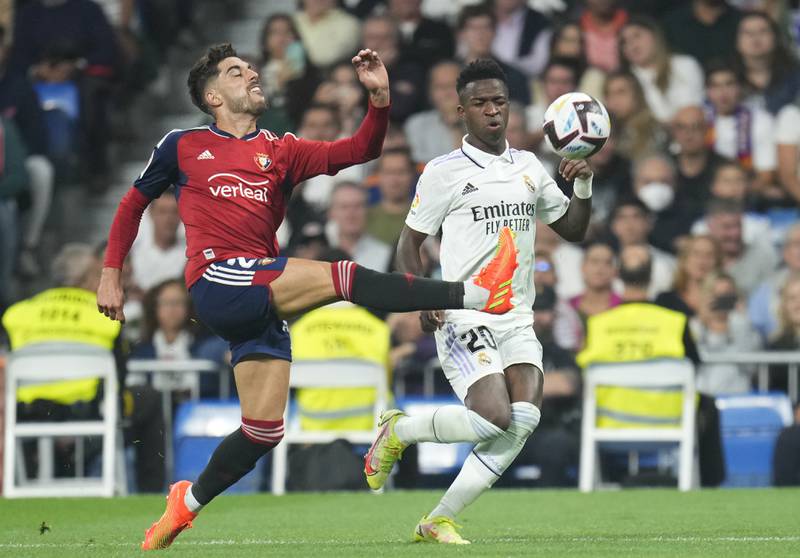 Osasuna's Nacho Vidal, left, challenges for the ball with Real Madrid's Vinicius Junior. AP