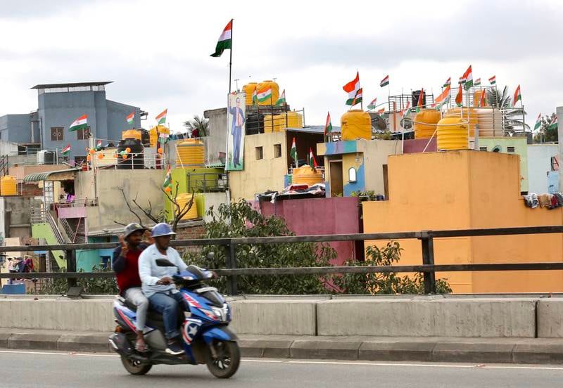 A scooter rides past houses flying the Indian tricolour in Bangalore. Prime Minister Narendra Modi's Har Ghar Tiranga campaign had urged Indians to hoist the national flag to mark Independence Day. EPA