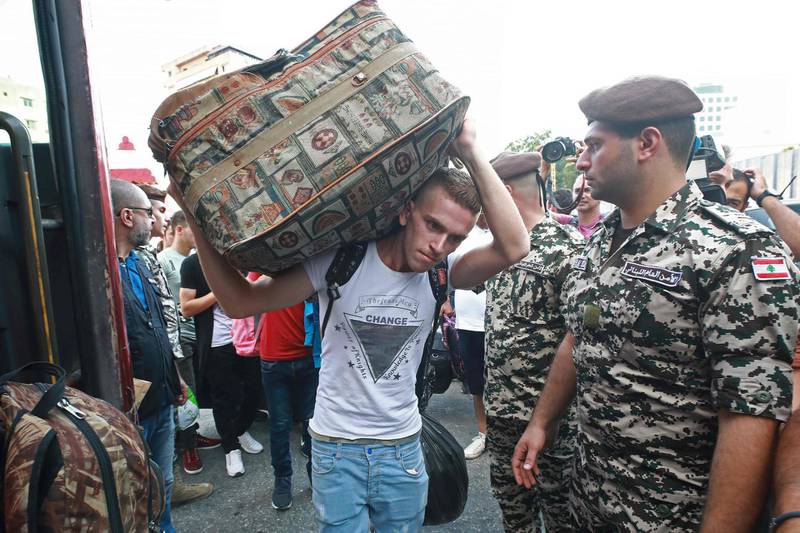 A Syrian man carries a luggage as refugees prepare to leave the Lebanese capital Beirut to return to their homes in Syria on September 9, 2018. - A group of Syrian refugees left the Lebanese capital for their homeland on September 9 as part of an organised operation coordinated between Lebanese and Syrian authorities. (Photo by ANWAR AMRO / AFP)