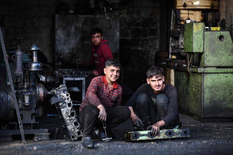 Young Syrian boys work at a car repair shop in the town of Jandaris, in the countryside of the north-western city of Afrin in the rebel-held part of Aleppo province, a day before the annual World Day Against Child Labour.