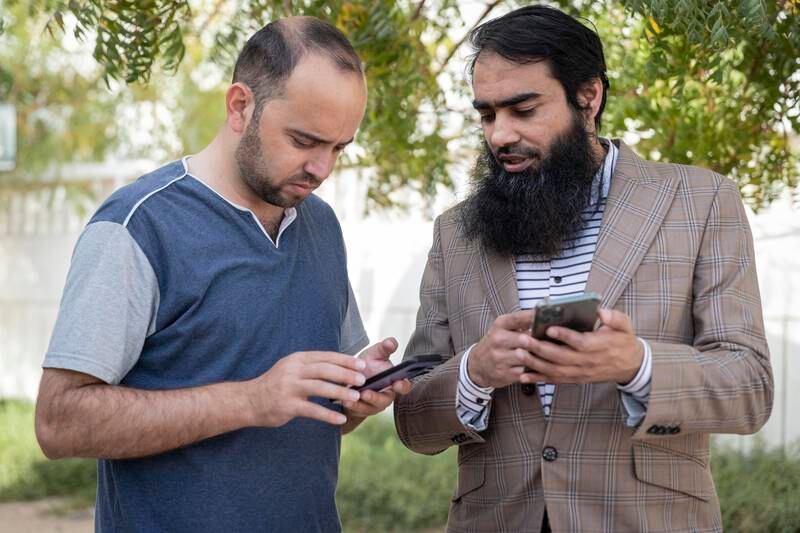 Tech engineer Abu Muadh (R) developed an app to help workers such as Abdul Qadeer (L) learn languages and improve work skills. Antonie Robertson / The National
