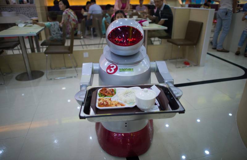 This photo taken on August 13, 2014, shows a robot carrying food to customers in a restaurant in Kunshan.  It's more teatime than Terminator -- a restaurant in China is electrifying customers by using more than a dozen robots to cook and deliver food. AFP PHOTO / JOHANNES EISELE (Photo by JOHANNES EISELE / AFP)