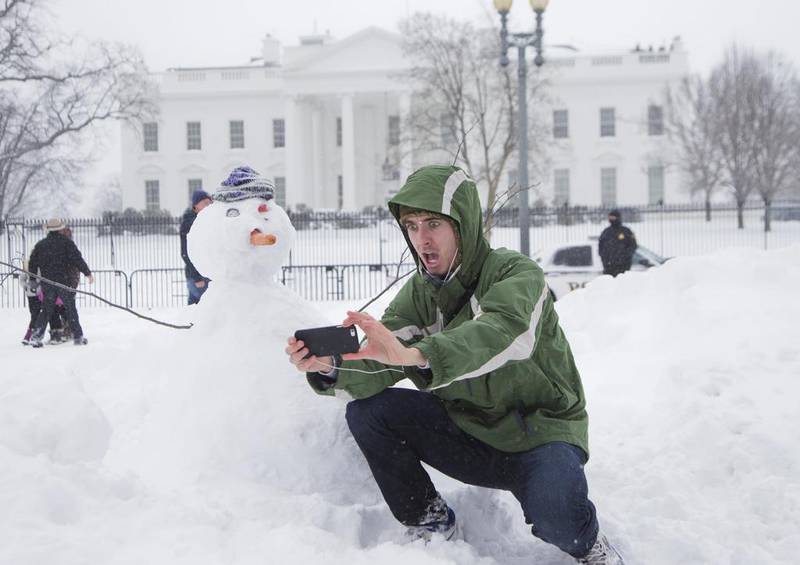 Harrison Feind of Boulder, Colorado, takes a selfie with a snowman in front of the White House in Washington. A blizzard with hurricane-force winds brought much of the East Coast to a standstill Saturday, dumping as much as 3 feet of snow, stranding tens of thousands of travelers and shutting down the nation’s capital and its largest city. Manuel Balce Ceneta / AP