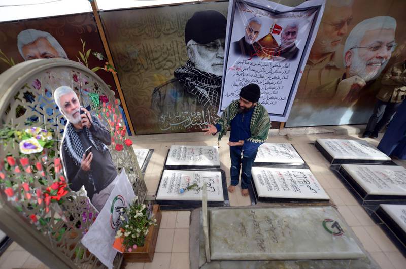A man mourns at the grave of Iraqi paramilitary commander Abu Mahdi al-Muhandis, at the Wadi al-Salam ("Valley of Peace") cemetery in the Iraqi Shiite holy city of Najaf, on February 19, 2020. Al-Muhandis was killed alongside a top Iranian general in a US drone strike in Baghdad on January 3, and his final resting place in the world's largest cemetery has gained near-holy status, becoming an anti-US magnet and a stop for thousands of Shiite pilgrims who pass through Najaf each day to visit the tomb of Imam Ali, son-in-law of the Prophet Mohammed. / AFP / Haidar HAMDANI
