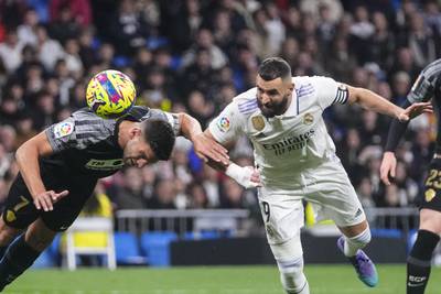 Real Madrid's Karim Benzema, right, heads the ball ahead of Elche's Lisandro Magallan. AP Photo