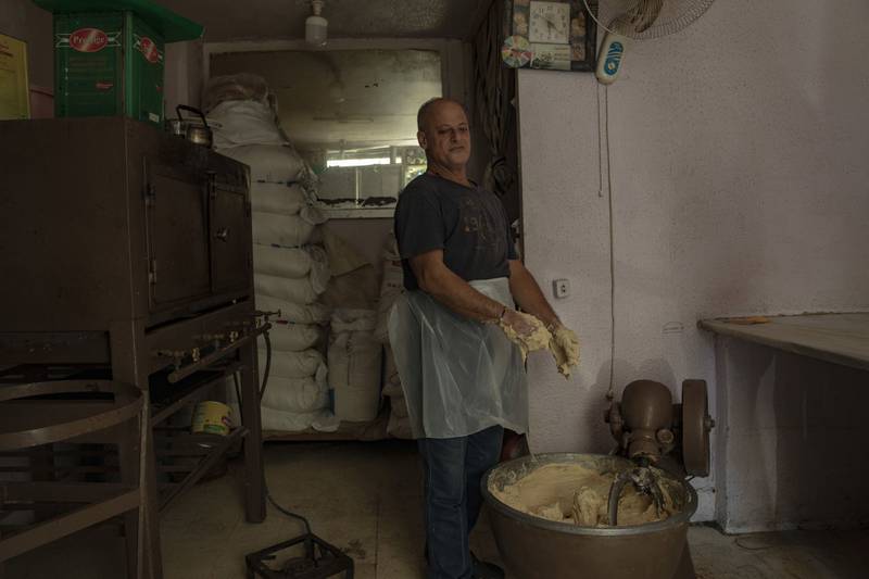 A worker is forced to knead dough by hand during a power cut in a bakery.