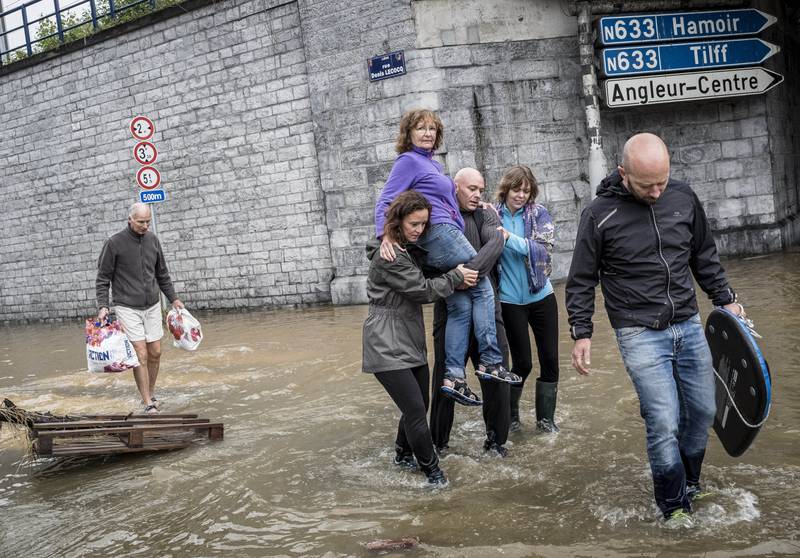 A woman is carried through a flooded street in Angleur, Belgium.