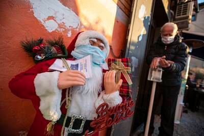 A Santa Claus puppet with the green pass and mask in Rome, Italy. EPA