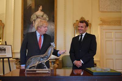 British Prime Minister Boris Johnson and French President Emmanuel Macron look at documents and artifacts related to former French president Charles de Gaulle, including a Cross of Lorraine, right, given as part of the Order de la Liberation to Winston Churchill in 1958, and a Lalique cockerel, left, given by de Gaulle to Clementine Churchill during the Second World War, at 10 Downing Street. Getty Images
