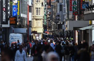 People walk past shops on a pedestrian street in Dortmund, western Germany, during the coronavirus pandemic. Some small shops in Germany reopened on Monday as the country took a cautious step toward returning to normal.   AFP